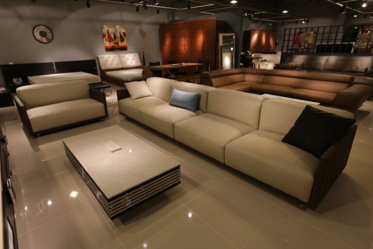 Showroom de móveis com sofá modular bege, mesa de centro retangular e poltronas em ambiente amplo
